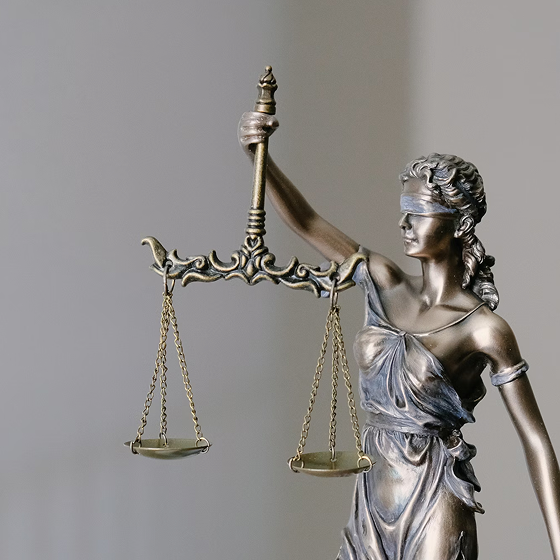 A statue of Lady Justice holding balanced scales in one hand and wearing a blindfold, symbolizing fairness and impartiality in law