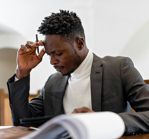A man with book and pen in thinking mood